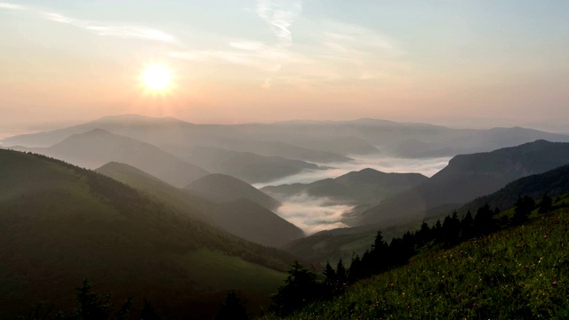 宁静的傍晚日落在绿色高山自然与薄雾在山谷视频素材