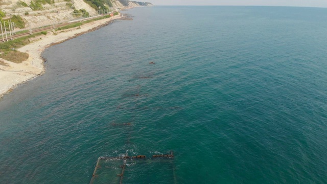 沿着海滩附近浅水中沉船的船体观看视频素材