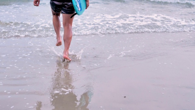 亚洲男人和他的冲浪板跑向海浪。旅游，生活方式和暑假概念。慢镜头，后视图视频素材