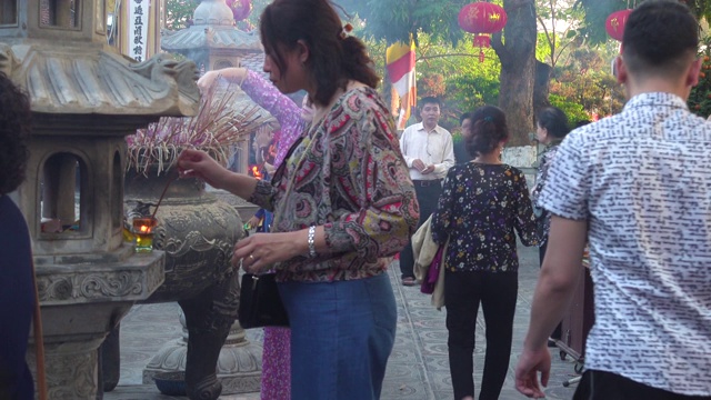 越南河内，一名女子在陈国佛塔寺的佛坛上焚香视频素材