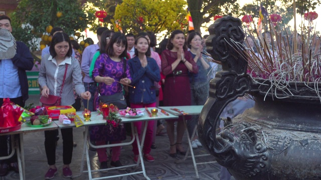 春节期间，人们在河内的陈国佛塔寺祈祷。在祭坛上焚香视频素材