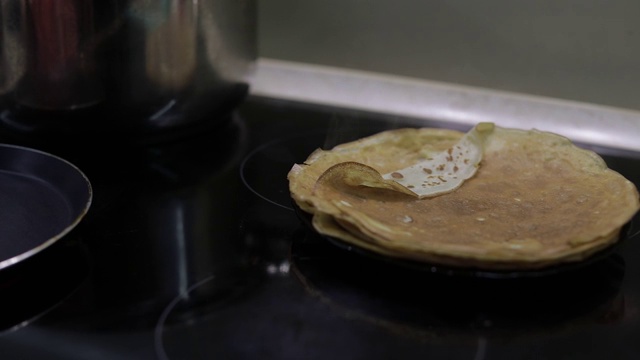 自制煎饼的制作过程。女人把煎饼从平底锅放到盘子里视频素材