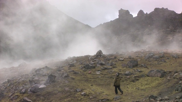 在多岩石的山区徒步旅行的摄影师。编辑只使用。视频素材