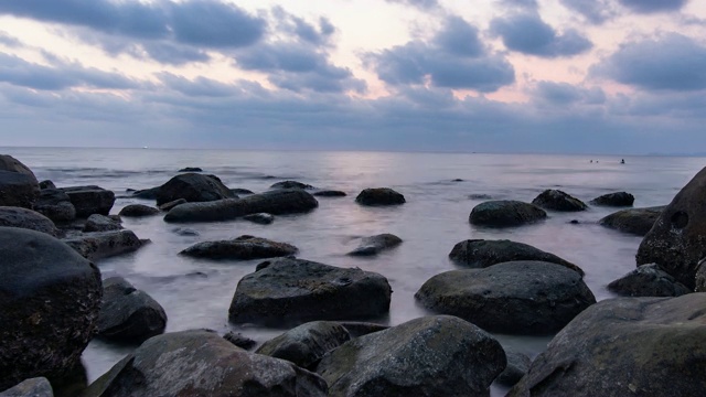 海洋和海滩与岩石在黄昏，时间流逝视频视频素材