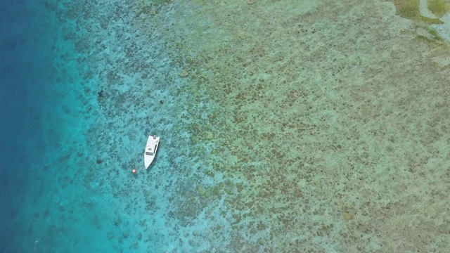 航拍:美丽海滩旁海面上漂浮的小船视频素材