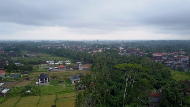 空中向前:多云天气热带小镇的农田视频素材