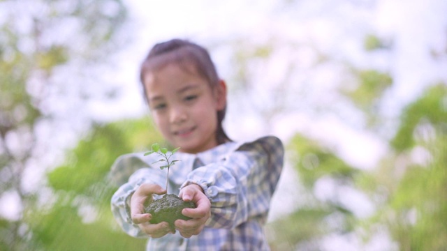 可爱的小亚洲女孩把小植物送给妈妈，拯救地球的理念。视频素材