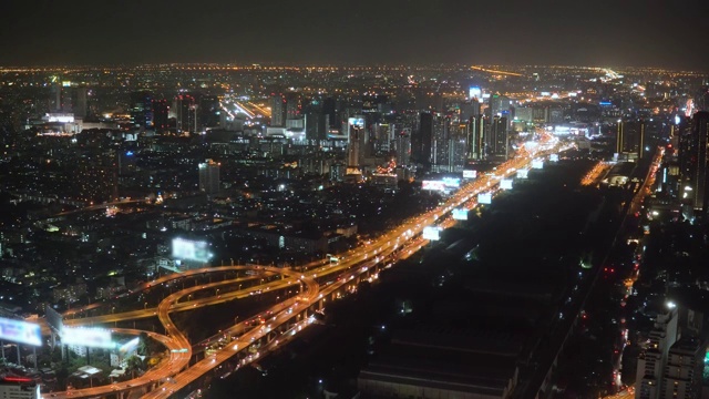 空中夜景照亮城市景观，滚动的城市街道现代建筑视频素材