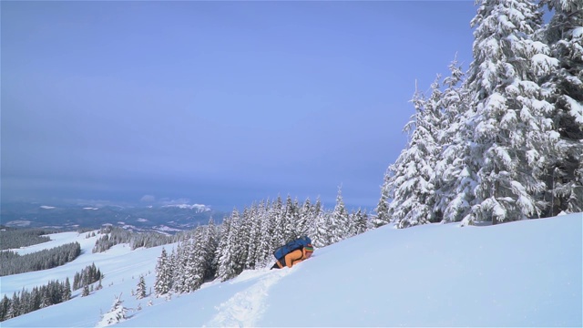 一位游客在山中的雪中行走。视频素材