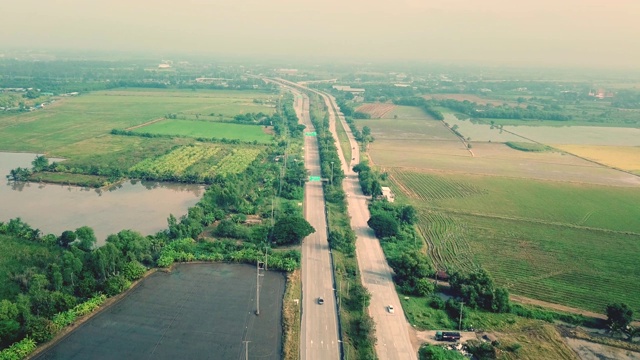 鸟瞰图，飞过高速公路和稻田视频素材