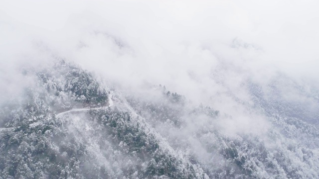 鸟瞰图，冬日雪山中蜿蜒的道路视频素材