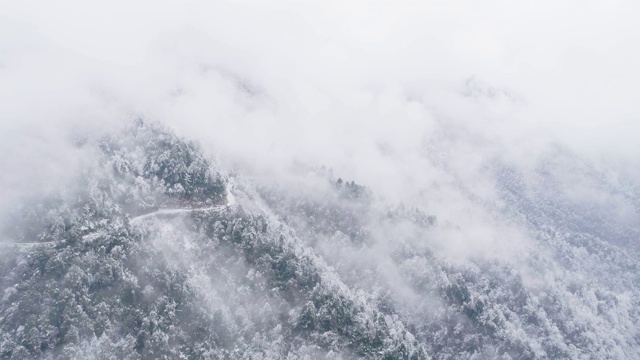 鸟瞰图，冬日雪山中蜿蜒的道路视频素材