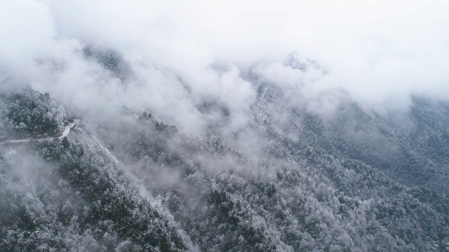 鸟瞰图，冬日雪山中蜿蜒的道路视频素材