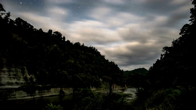 在黑暗的星空中，云在新西兰旺加努伊河上空快速移动视频素材