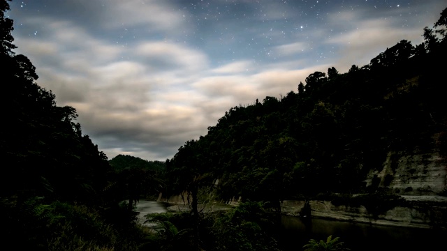 云天空快速移动在旺加努伊河在黑暗的夜晚与星星在新西兰自然时间流逝视频素材