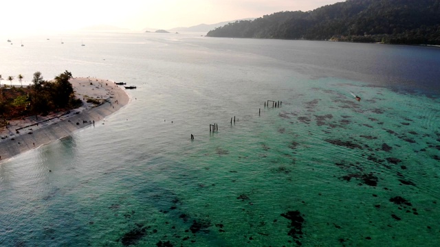 落日余辉中，翠绿的热带海洋和白色沙滩视频素材