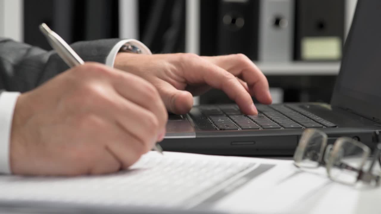 Businessman working and calculating finance. He reads and writes reports. 企业财务会计概念。特写镜头。视频素材