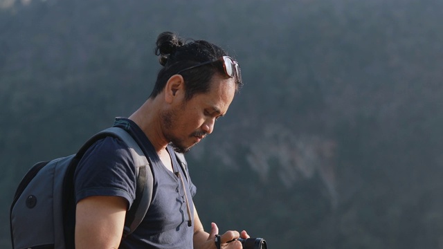 亚洲男人背包和旅行者一起散步和快乐的森林拍照，放松时间的假日概念旅行视频素材