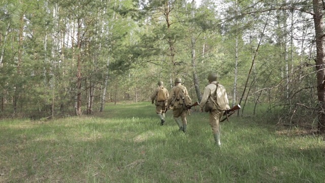 俄罗斯苏联步兵红军士兵在夏季沿着森林路行走。一群士兵在森林中行进视频素材