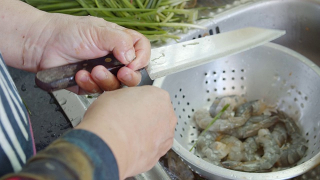 亚洲妇女手洗和清洁虾准备烹饪食物。视频素材