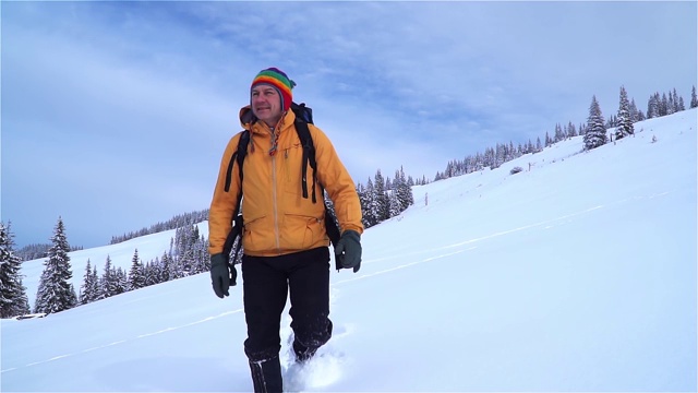 一位游客在山中的雪中行走。视频素材