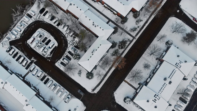 鸟瞰被雪覆盖的城市街道和房屋在雪冬天的道路覆盖视频素材