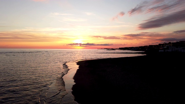 美丽的日落在罗马海岸在奥斯提亚利多与平静的海，水面上的倒影壮观的天空和放松的气氛视频素材