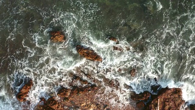 空中鸟瞰海浪和岩石海岸在白天。由4K分辨率的无人机拍摄视频素材