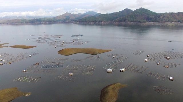 水力发电大坝水库在山区的科迪勒拉山脉形成巨大的湖泊，在那里水鱼养殖兴旺。无人机空中拍摄视频素材