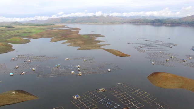 水力发电大坝水库在山区的科迪勒拉山脉形成巨大的湖泊，在那里水鱼养殖兴旺。无人机空中拍摄视频素材