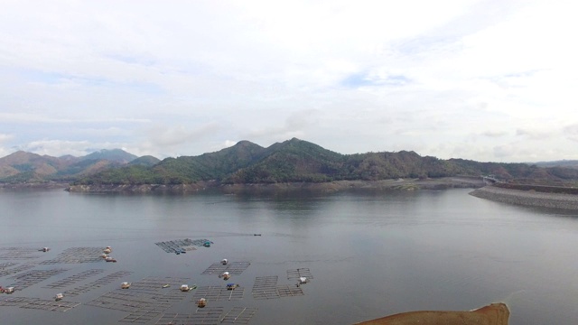 水力发电大坝水库在山区的科迪勒拉山脉形成巨大的湖泊，在那里水鱼养殖兴旺。无人机空中拍摄视频素材