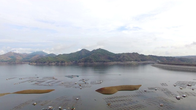 水力发电大坝水库在山区的科迪勒拉山脉形成巨大的湖泊，在那里水鱼养殖兴旺。无人机空中拍摄视频素材