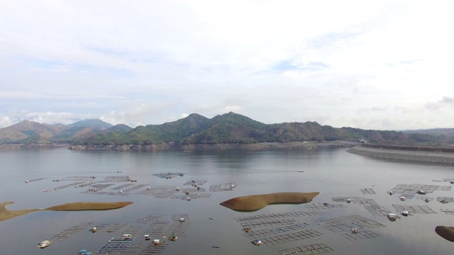 水力发电大坝水库在山区的科迪勒拉山脉形成巨大的湖泊，在那里水鱼养殖兴旺。无人机空中拍摄视频素材