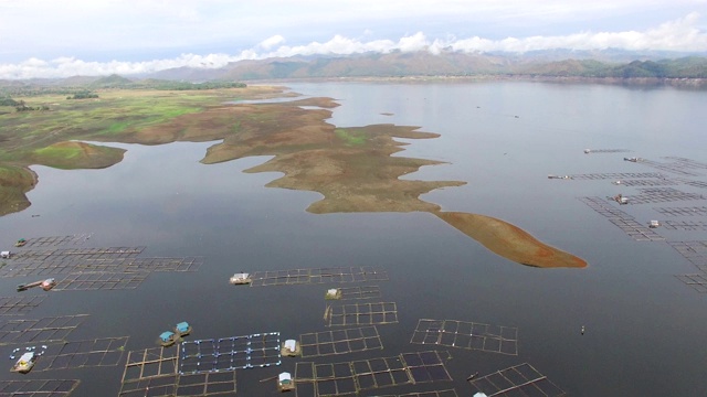 水力发电大坝水库在山区的科迪勒拉山脉形成巨大的湖泊，在那里水鱼养殖兴旺。无人机空中拍摄视频素材