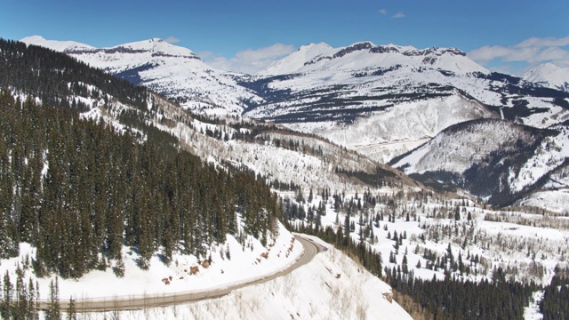 百万美元高速公路蜿蜒穿过雪山景观-空中视频素材