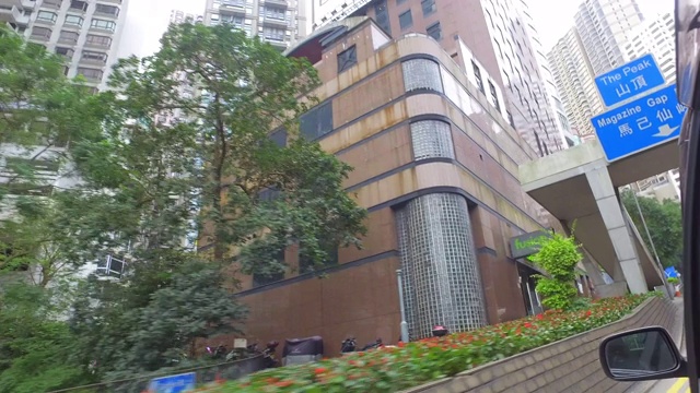 在香港的街道上开车经过绿树和高楼大厦-香港，中国视频素材