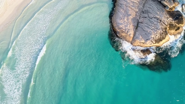 空中攀登:明亮的蓝色海浪撞击在傍晚的褐色岩石上-埃斯佩兰斯，澳大利亚视频素材