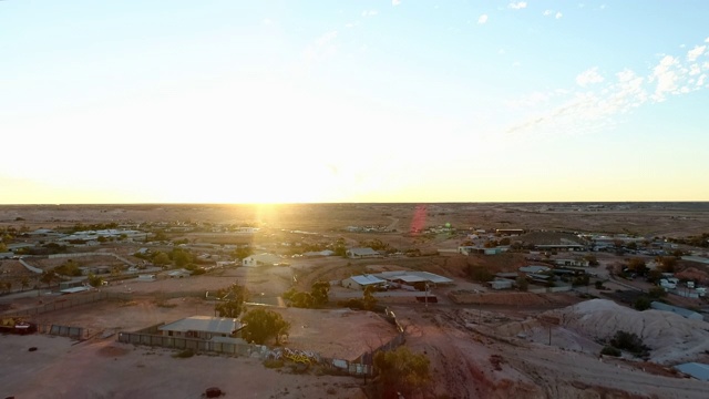 空中降落:澳大利亚乌卢鲁平原上的大型建筑，地平线上有日落视频素材