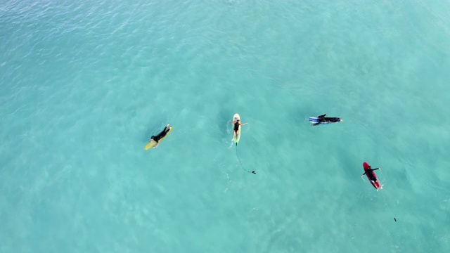 空中封锁:冲浪者在浅蓝色海水中的彩色冲浪板上——埃斯佩兰斯，澳大利亚视频素材