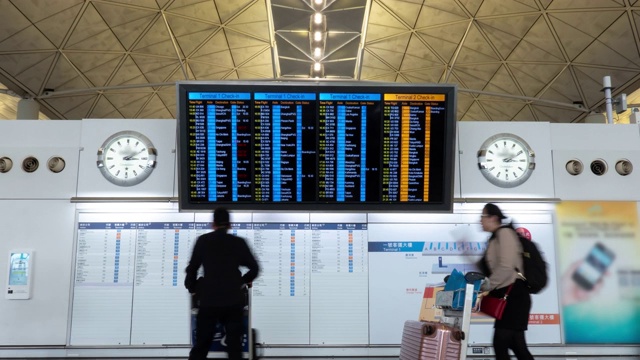 4K时光流逝:旅客及游客查询香港机场内的航班时间表视频素材