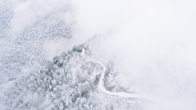 鸟瞰图，冬日雪山中蜿蜒的道路视频素材