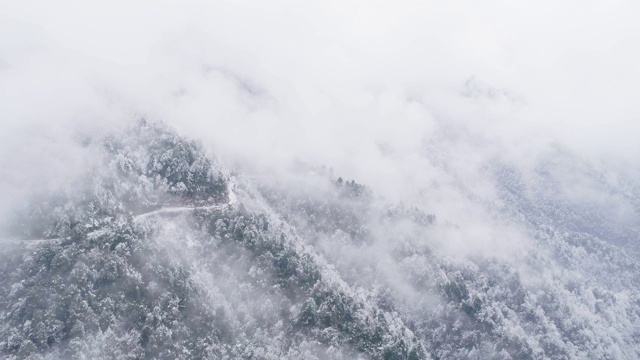 鸟瞰图，冬日雪山中蜿蜒的道路视频素材