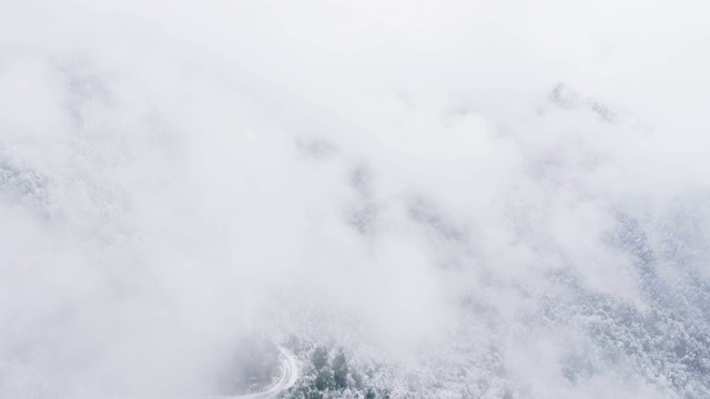 鸟瞰图的雪山覆盖在雾在冬天的一天视频素材