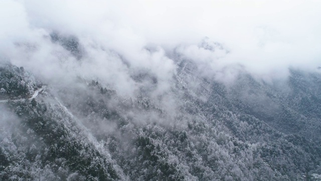 鸟瞰图，冬日雪山中蜿蜒的道路视频素材