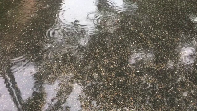 涟漪般的雨滴落在水泥地板上视频素材