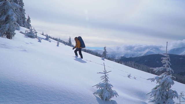 游客背着背包爬上雪坡视频素材