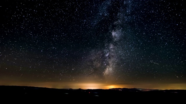 黑暗的夜晚，星空和银河在自然景观之上天文时间流逝视频素材