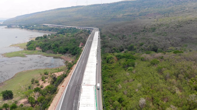 无人机拍摄的高速公路正在建设中，高速公路通行费接近天然的大江和大山视频素材