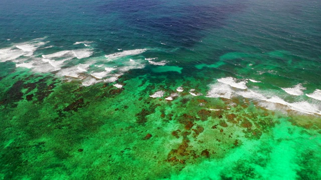 空中向前:尼加拉瓜小玉米岛的岩石浅滩上明亮的绿色海水视频素材