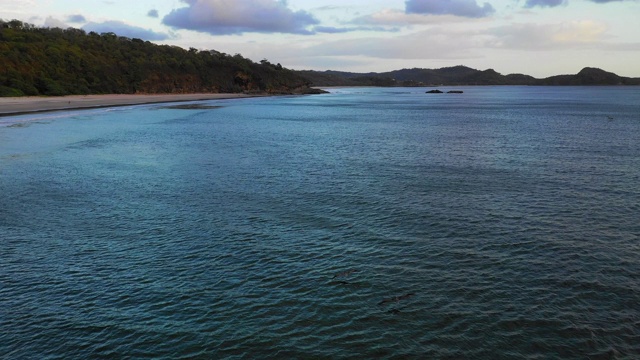 空中向前:深蓝色的海洋，海岸上有森林覆盖的山丘-尼加拉瓜埃尔吉甘特视频素材